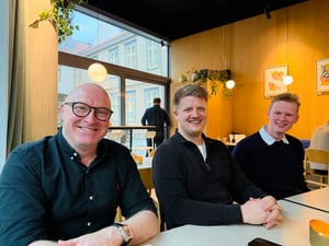 Tre personer som smiler